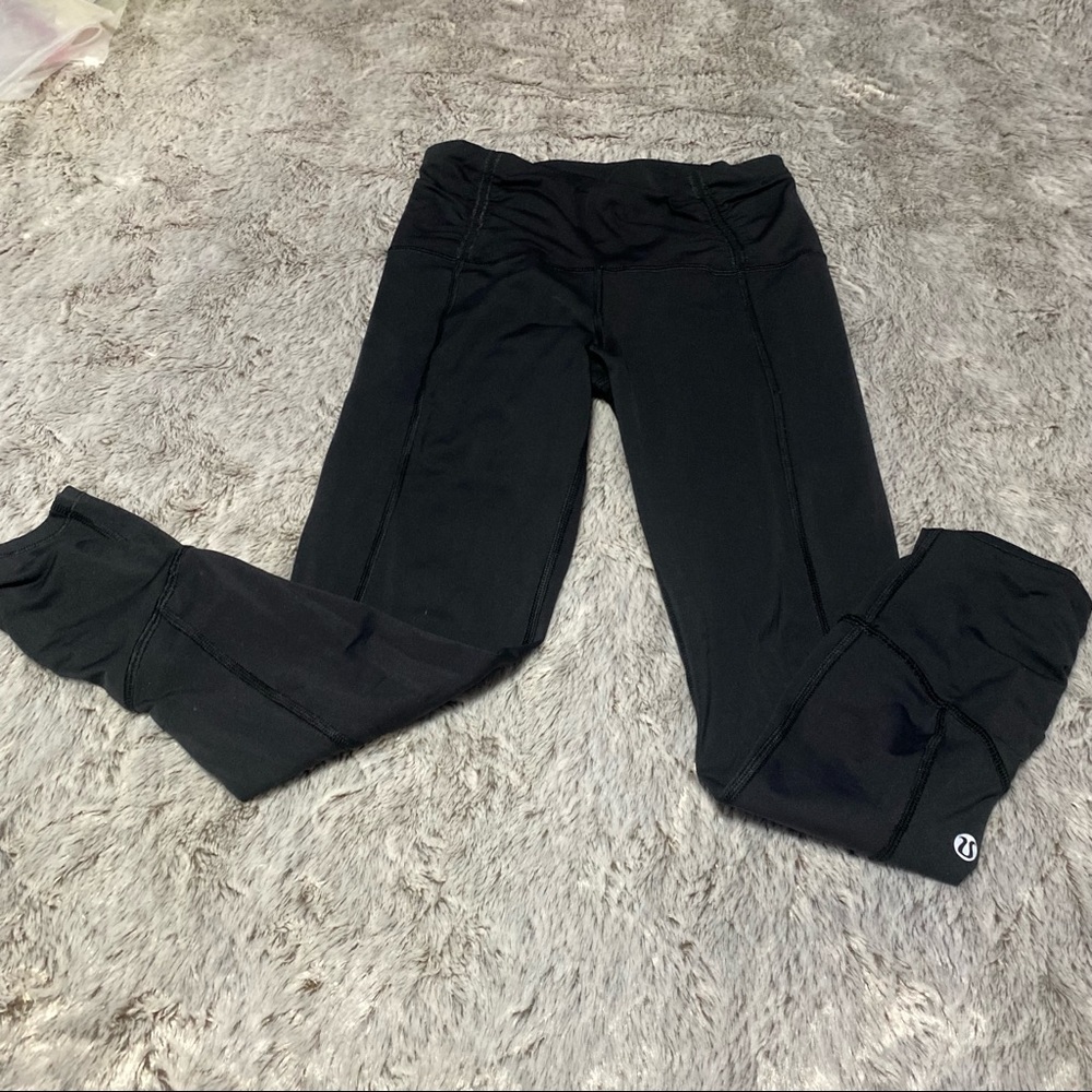 LuLuLemon black leggings with reflective stripe and zipper at the ankles